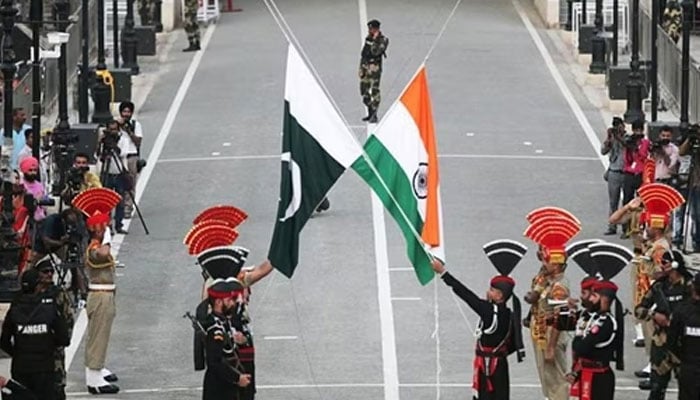 Pakistani rangers and Indian Border Security Force (BSF) officers lower their national flags during a daily parade at the Pakistan-India joint check-post at Wagah border, near Lahore. — Reuters/File