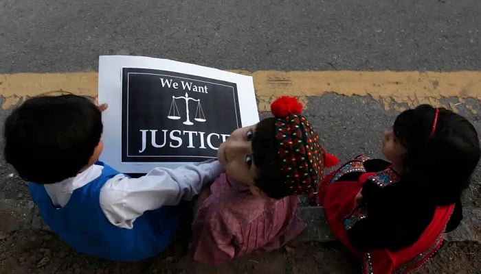 Children sit with a placard on a roadside during a protest by members of a civil society, against the rape of a five-year-old girl from Lahore, in Islamabad.—Reuters/File